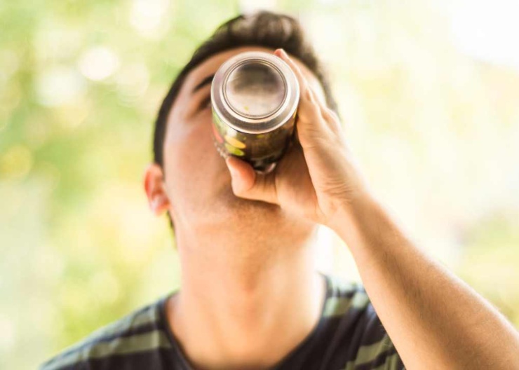 Ragazzo beve una bibita in lattina