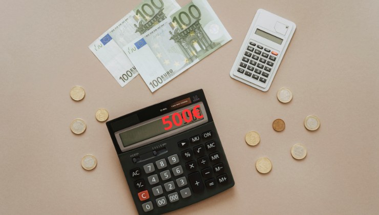Calcolatrice ed euro sparsi sul tavolo