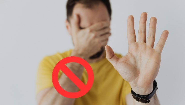 Uomo con mano in faccia e con l'altra aperta in avanti